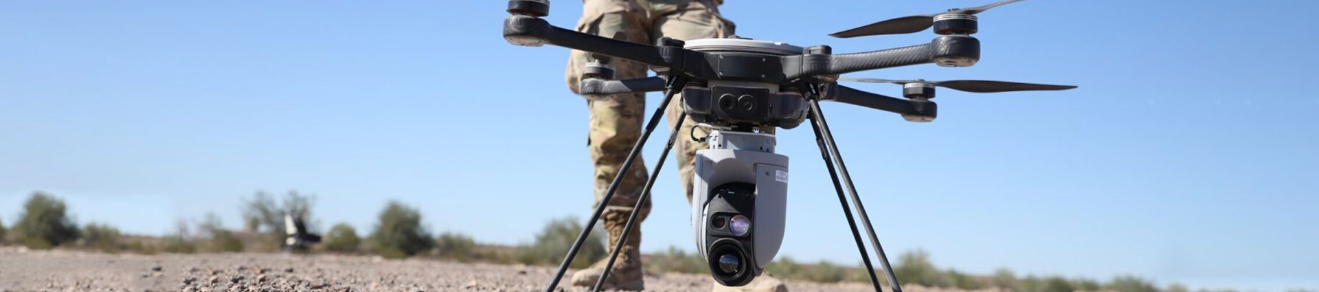 Soldier flying drone in desert