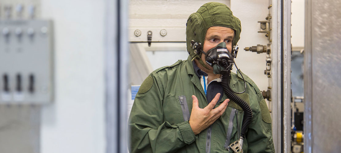Hypobaric Chamber with user wearing breathing apparatus helmet and flight suit