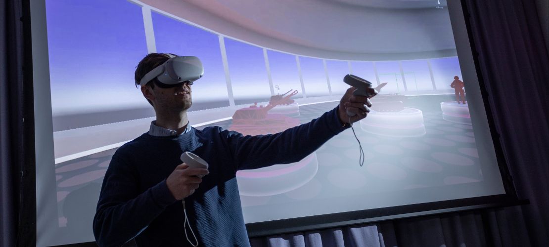 Man wearing VR headset in front of military graphics