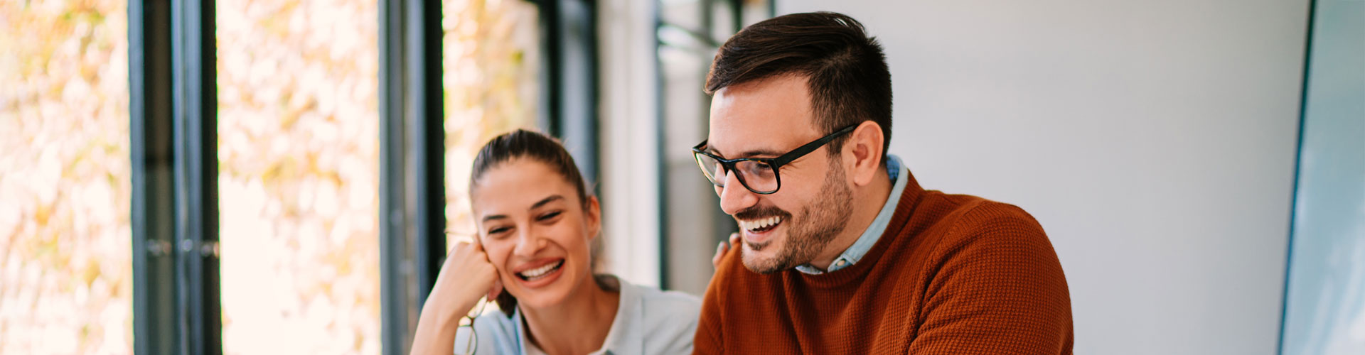 Employees smiling at a laptop screen