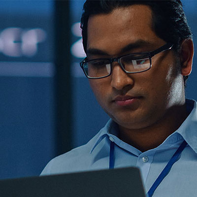 Man looking at laptop with cyber background