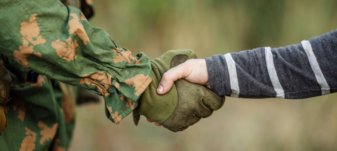 Armed forces shaking hands with civilian