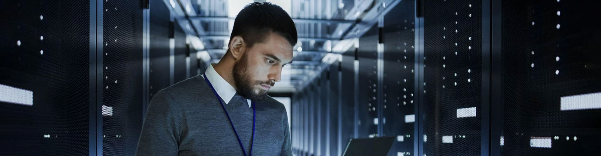 Person using a laptop while standing in a data center