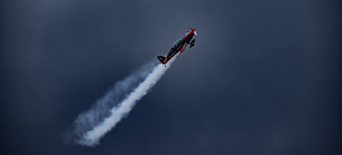 Aircraft with jet stream in dark sky