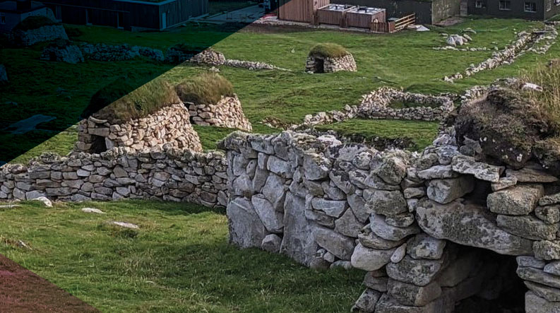 A view of several traditional, dry-stone storage huts called cleits, with turf roofs, in the village area of Hirta, St Kilda.