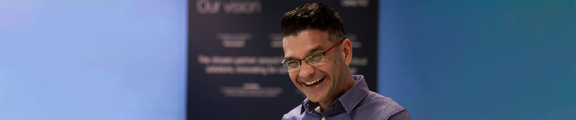 Employee smiling in front of vision statement