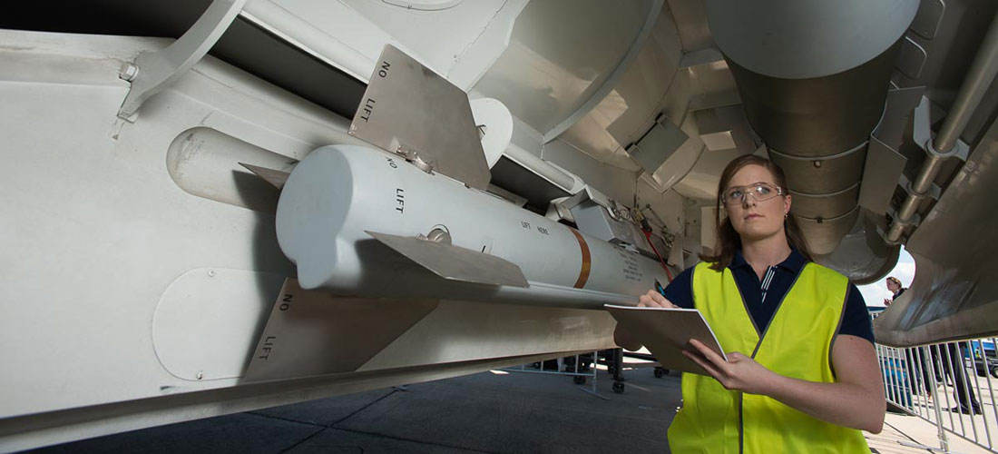 Explosive Ordnance Engineer standing underneath aircraft
