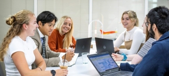 Some of QinetiQ's graduates sitting around a meeting table